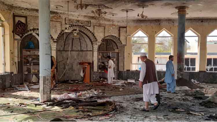 कुंदुज की मस्जिद में विस्फोट के मलबे में अपने परिजनों का सामान खोजते हुए 