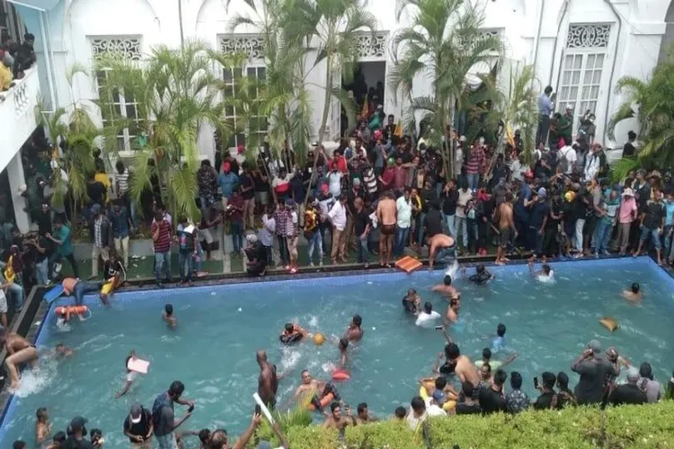 श्रीलंका : प्रदर्शनकारी  राष्ट्रपति के स्विमिंग पूल में डुबकी लगाते, पीएम के बिस्तर पर दिखे