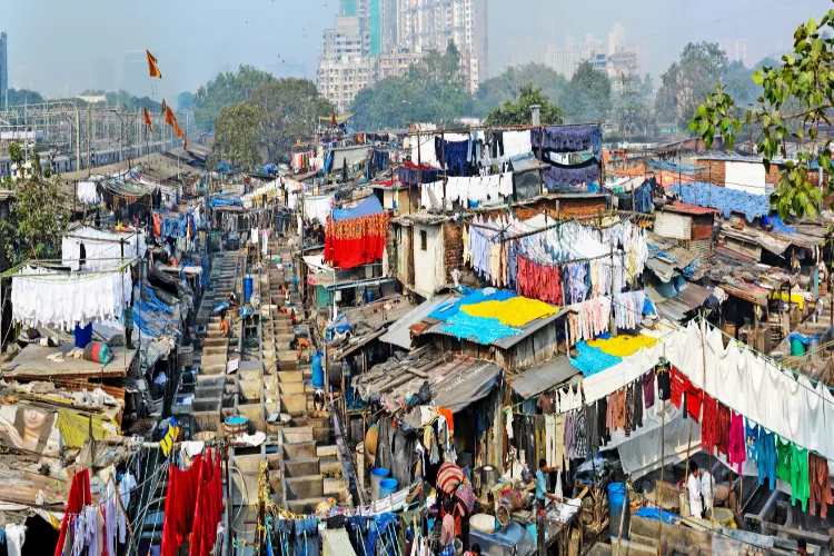 Why does the wheel of development stop in slums?