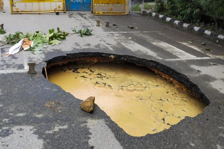 A portion of a road caved in after heavy rains in Delhi's Janakpuri area