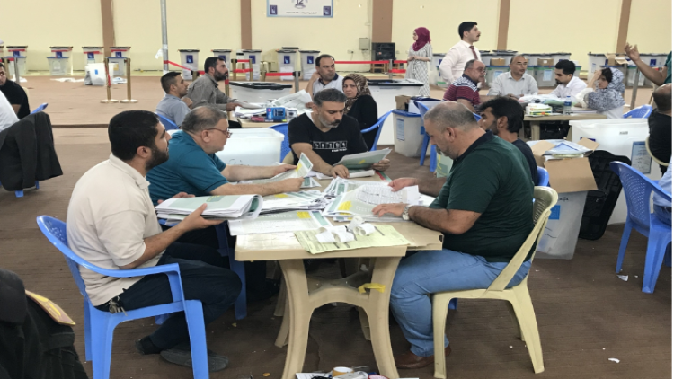 इराक में चुनाव प्रक्रिया पूरी करते कर्मचारी