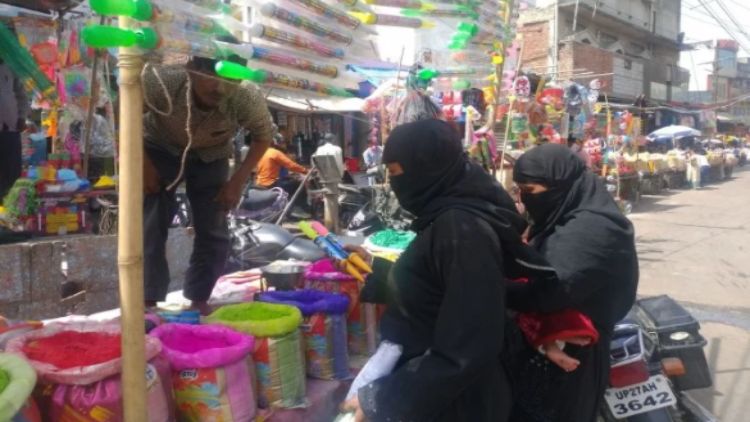 उत्तर प्रदेश के शाहजहांपुर के बाजार में मुस्लिम महिलाएं अपने बच्चों के लिए पिचकारी खरीदती हुईं